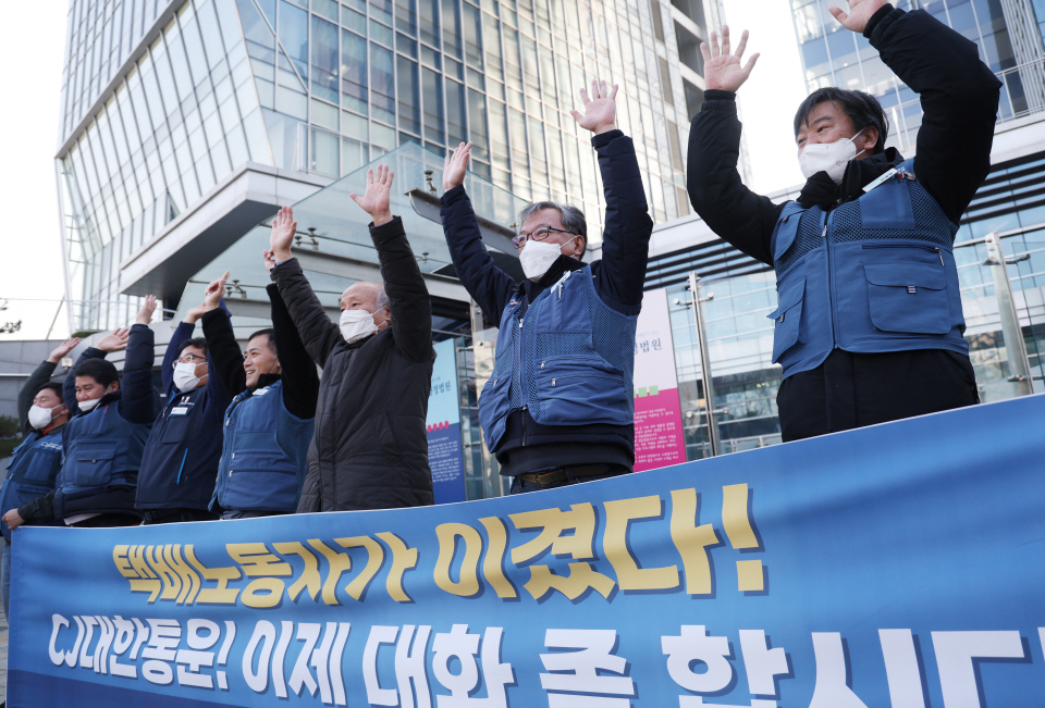 진경호 민주노총 전국택배노조 위원장(오른쪽에서 두 번째)을 비롯한 택배노조 조합원들이 지난 12일 CJ대한통운이 택배기사와 단체교섭을 거부하는 건 부동노동행위라는 중앙노동위원회 판정에 손을 들어준 서울행정법원의 판결이 나온 뒤 만세를 외치는 모습. [사진=연합뉴스]