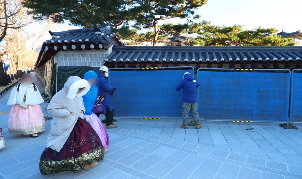 17일 오전 경복궁 담벼락 낙서 제거 준비 작업이 진행되고 있는 서울 종로구 국립고궁박물관 쪽문 경복궁 담벼락 앞으로 관광객들이 지나고 있다.(사진=연합뉴스)