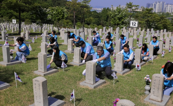 프리드라이프 임직원들이 지난 23일 서울 동작구 국립서울현충원에서 묘역 정화활동을 하고 있다. (사진=프리드라이프)